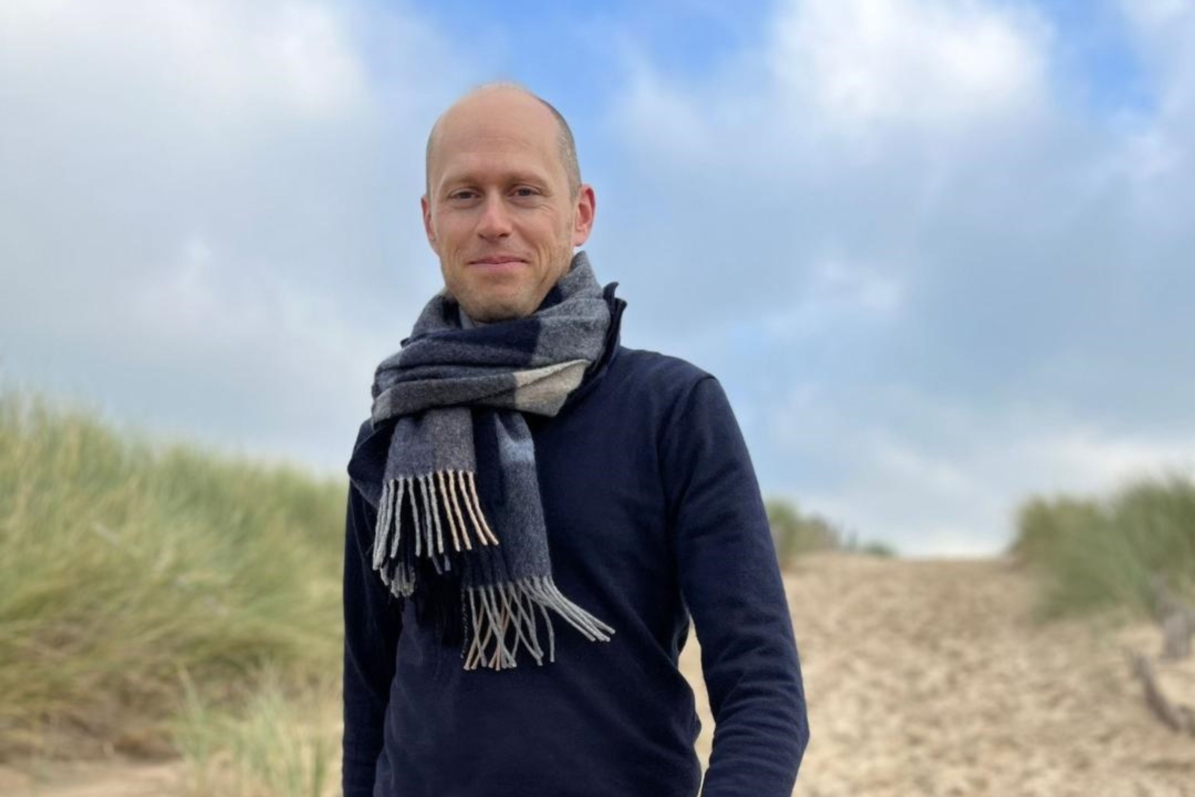 raadslid Sander Croes loopt op het strand langs de duinen